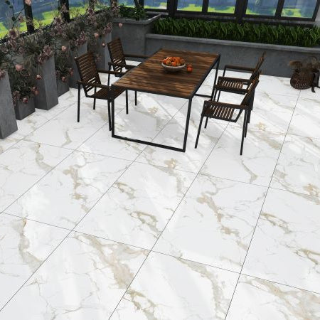 Large white marble-look floor tiles with beige veining, shown installed in an outdoor patio setting with a wooden dining table and chairs.